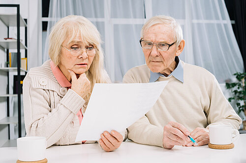 Couple look with concern at a bill they have received